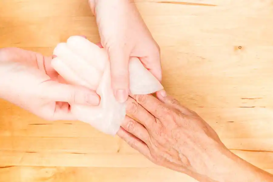 Ergotherapie auf Reha: Patientin beim Paraffinbad Ergotherapie auf Reha: Patientin beim Paraffinbad