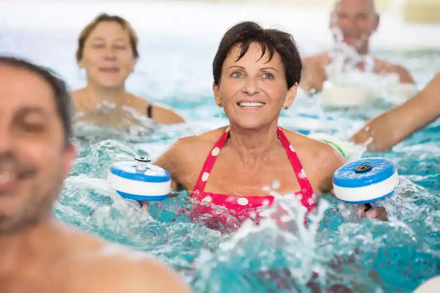 Patientin lacht bei der Wassergymnastik